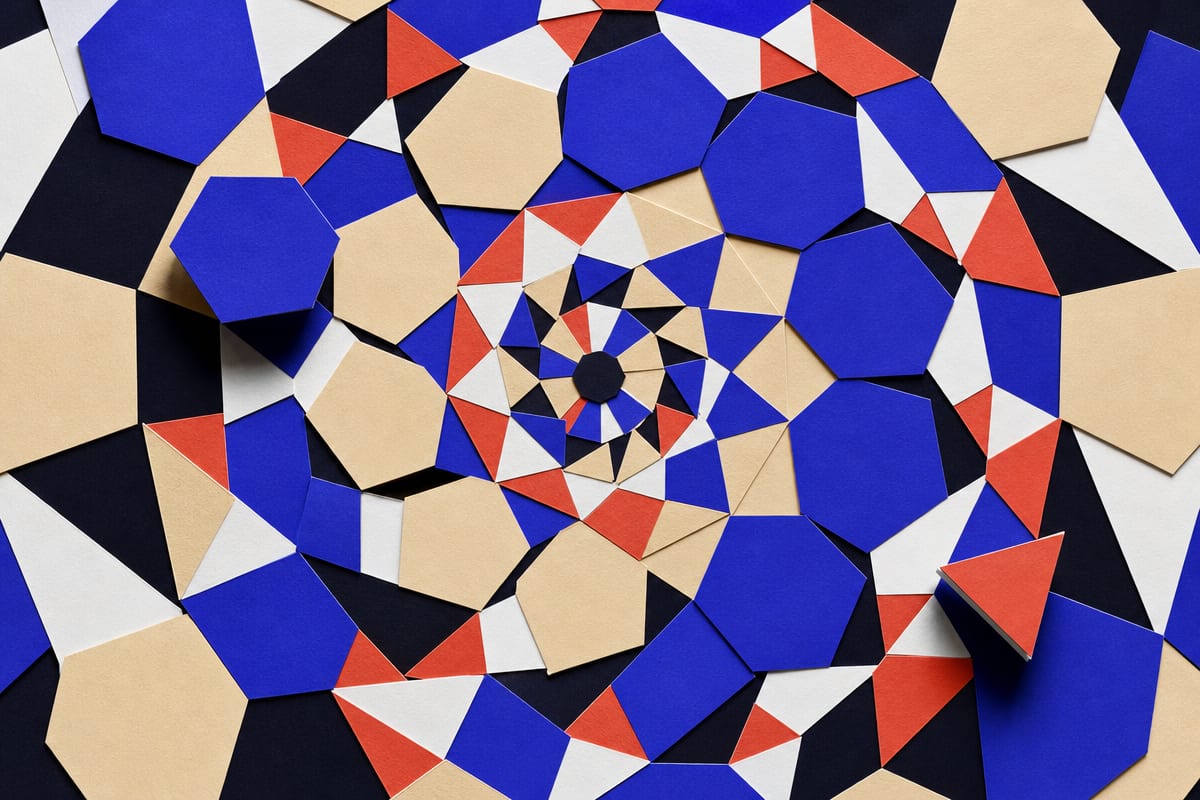 Cut-paper tiles rotating about a single centre, each ring turned further than the last